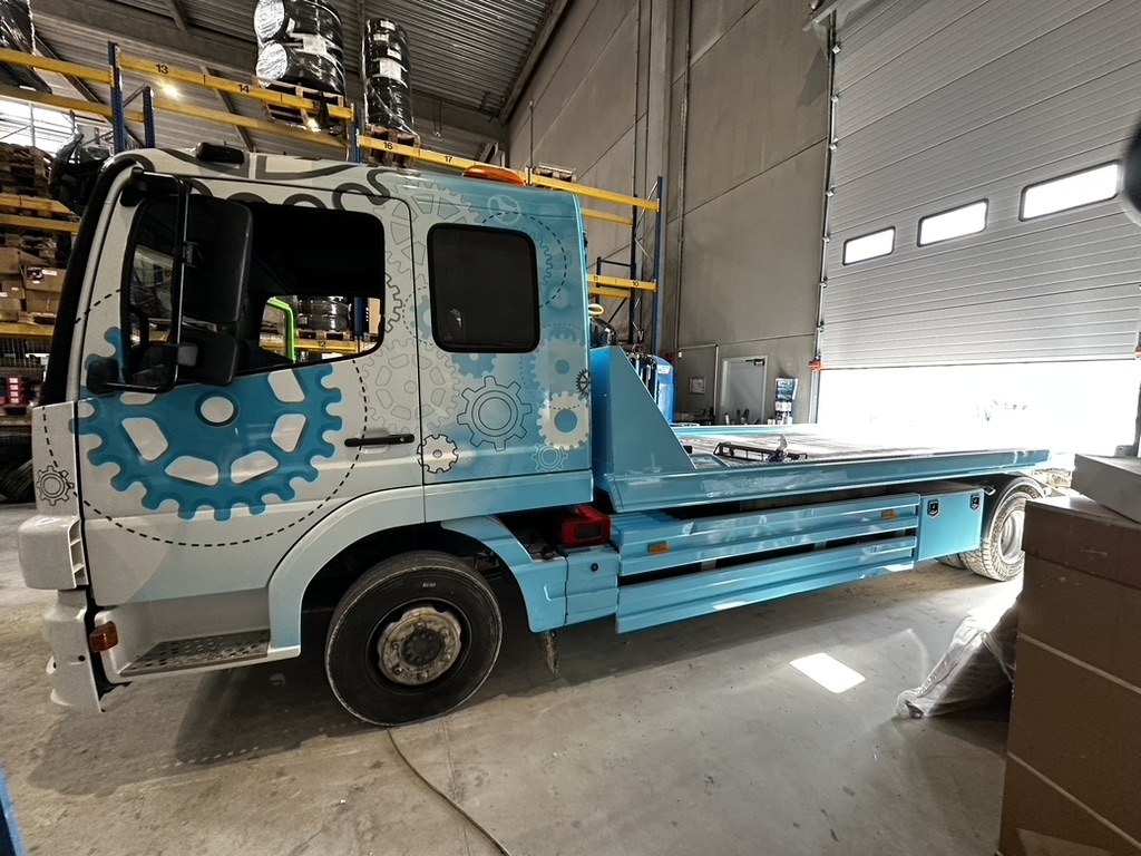 Véhicule plateau du service technique OC LOGISTIQUE dans le bâtiment